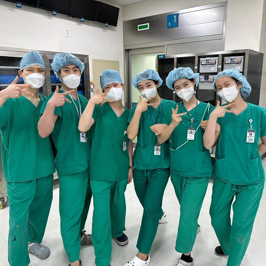 Internship colleagues in green scrubs and surgical caps
