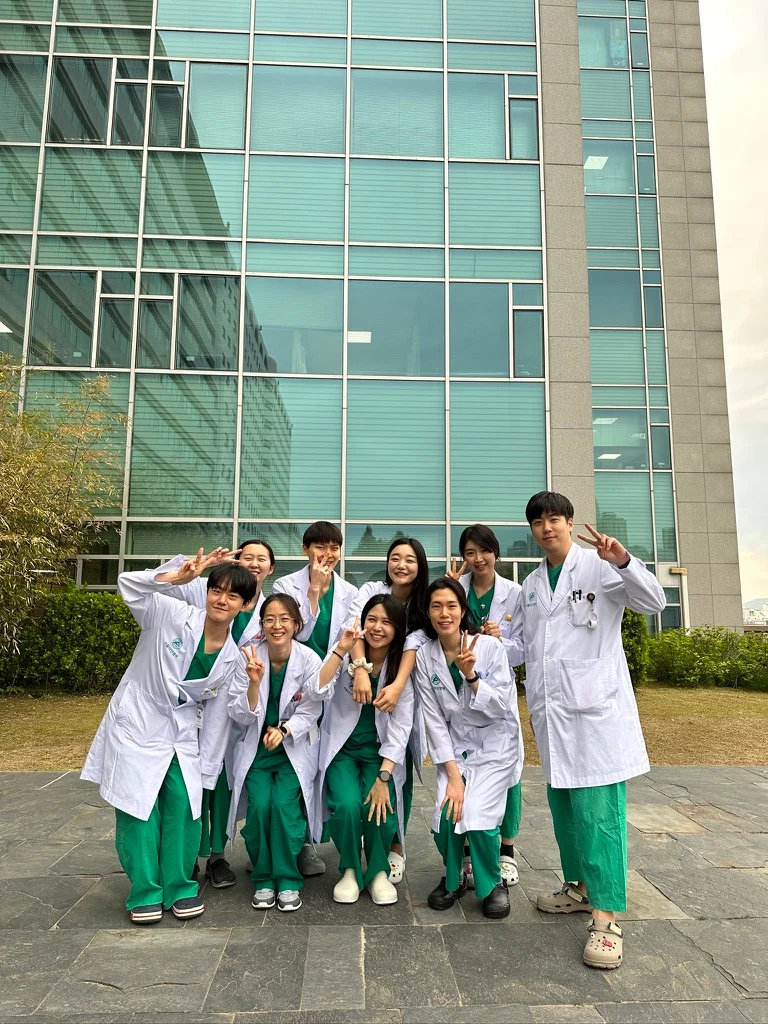 Internship colleagues wearing white coats outside the hospital