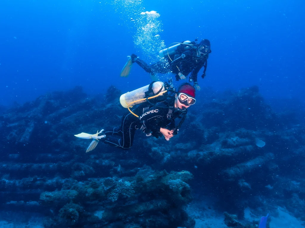 Scuba divers swimming over an underwater reef
