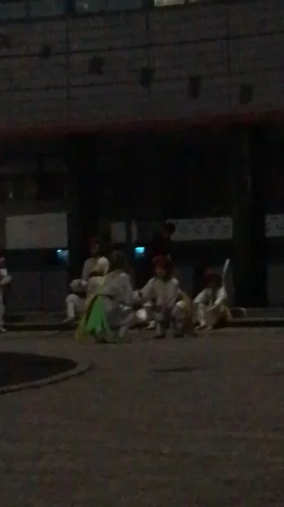 A low-light photograph of performers in traditional clothing