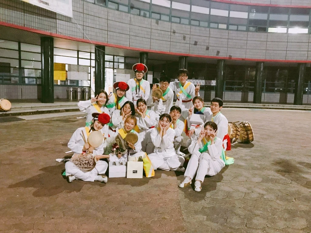 Percussion ensemble members gathered with instruments and flowers