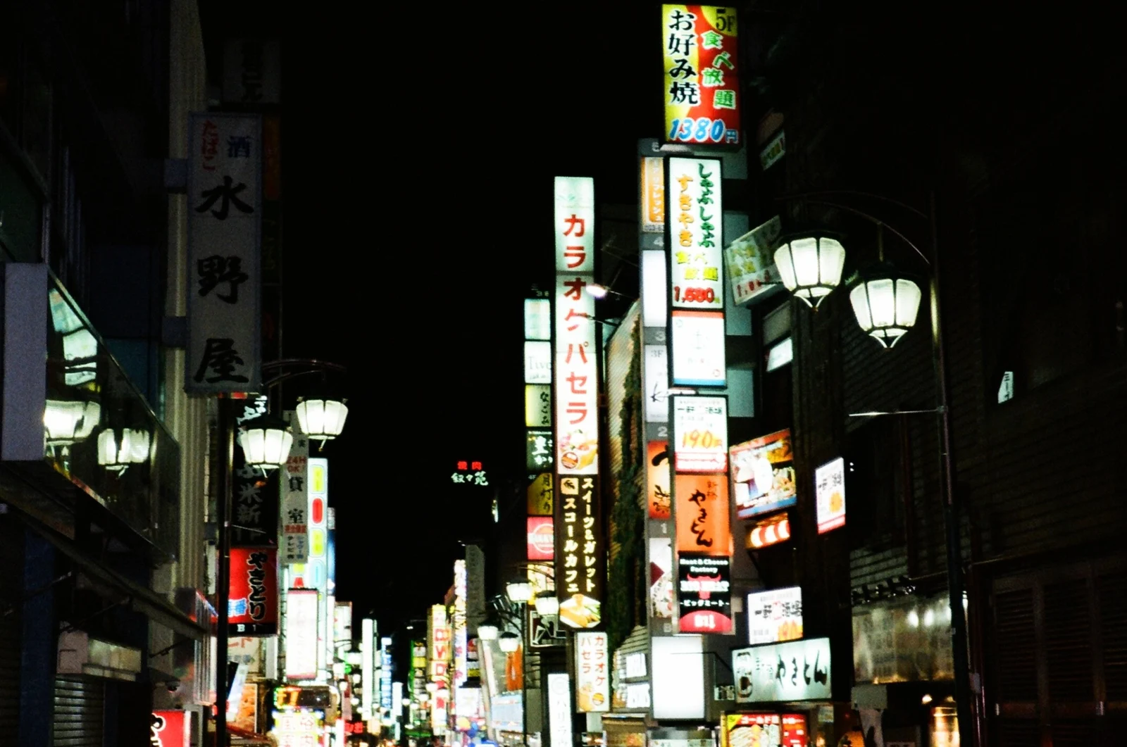 An illuminated street at night photographed on film