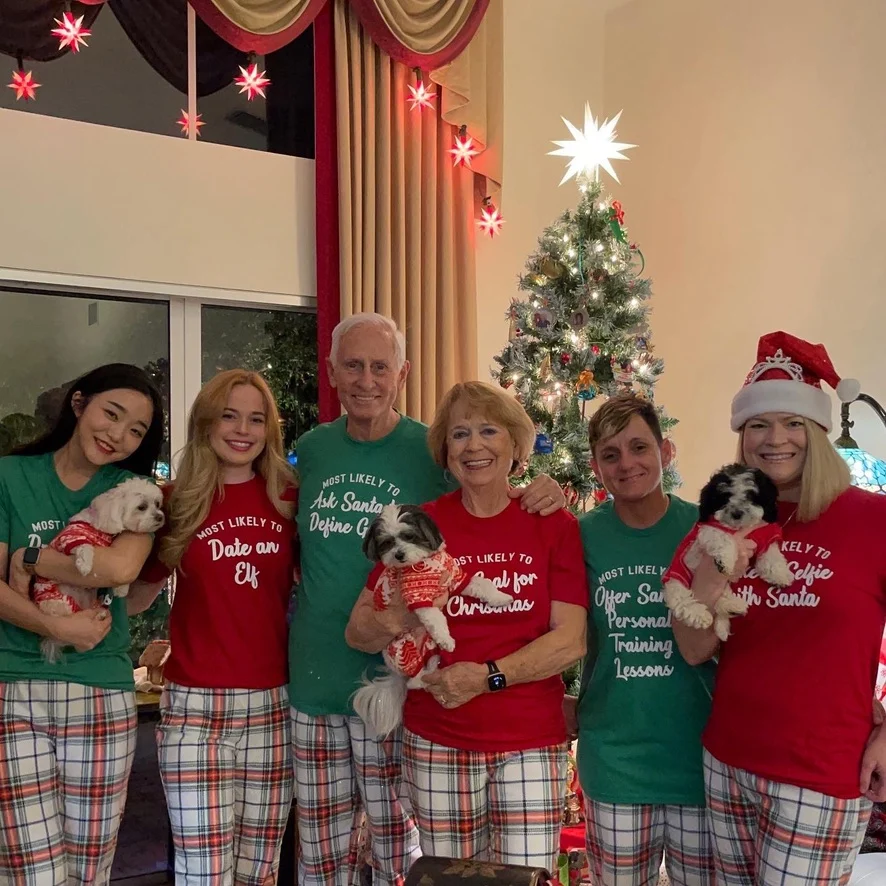 A Christmas group photograph in matching festive clothes with dogs