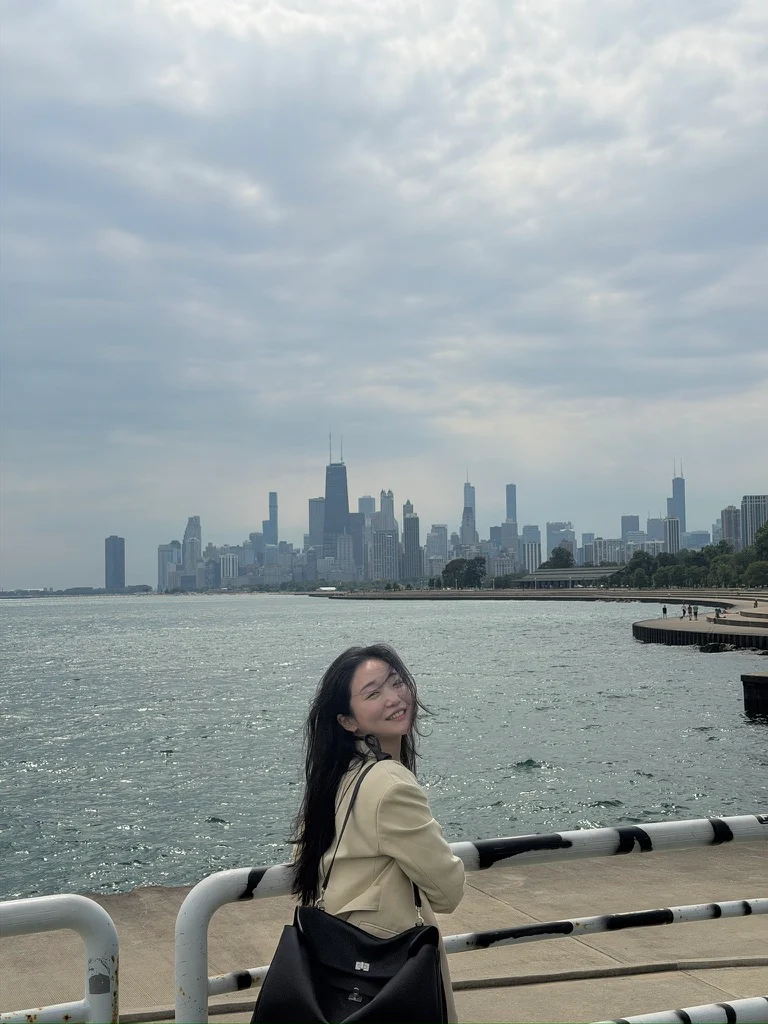 A traveler beside a lake and city skyline