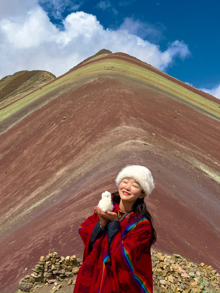 A traveler in front of a banded mountain landscape