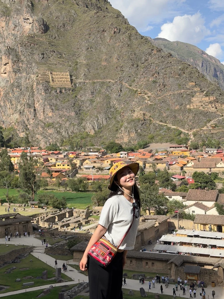 A traveler overlooking a town and mountain ruins