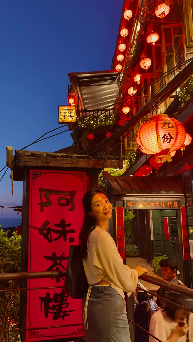 A traveler beside a lantern-lit tea house