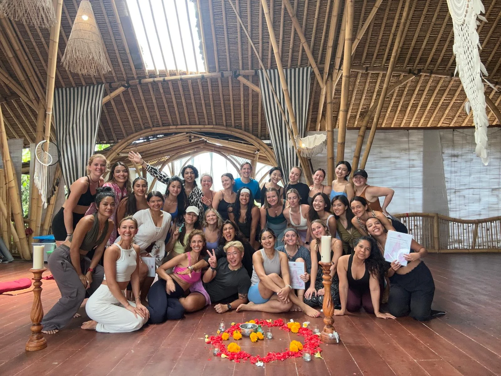 A group photograph with fellow yoga teacher trainees in a bamboo studio